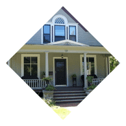 Large home with expansive elegant front porch with white pillars.