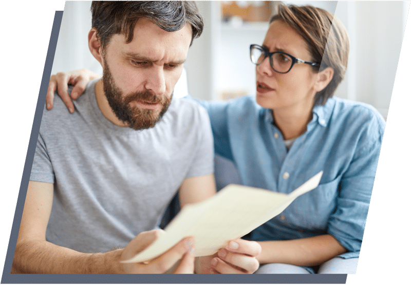 Man and women sitting next to each other looking concerned