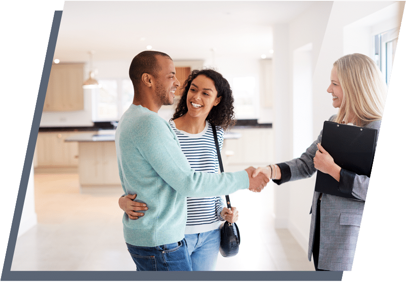 Young couple smiling and shaking hands with a businesswoman