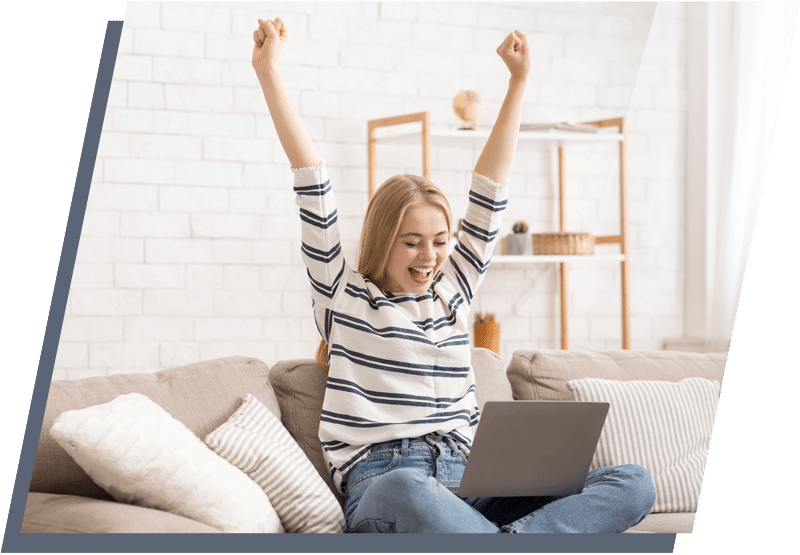 Woman sitting on a couch looking happy with her arms in the air