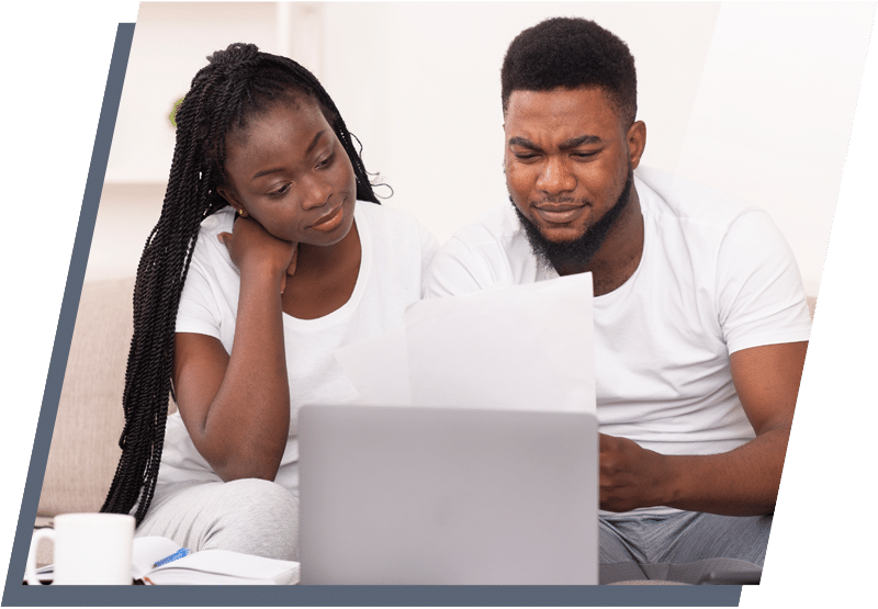 Young man and woman sitting behind a laptop and looking at documents