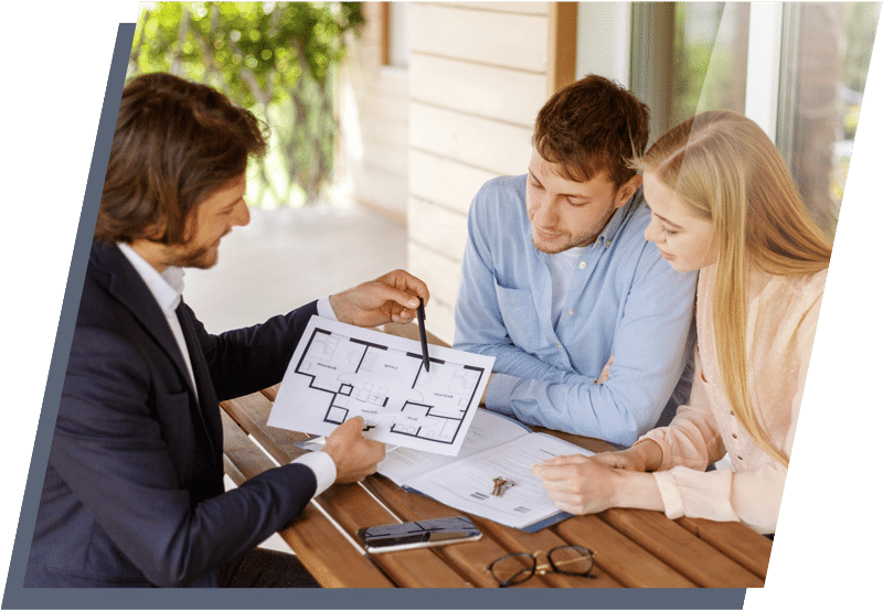 A young man and woman sitting across from a businessman looking at floorplans