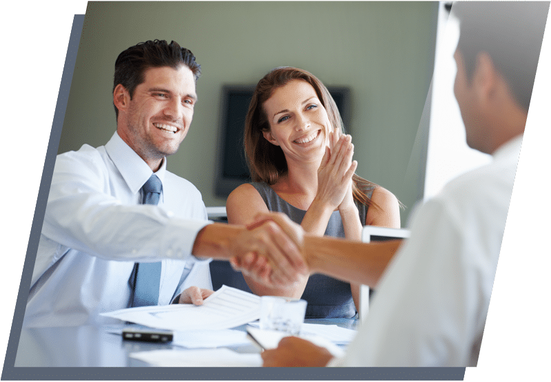 Men shaking hands across a table with a woman smiling