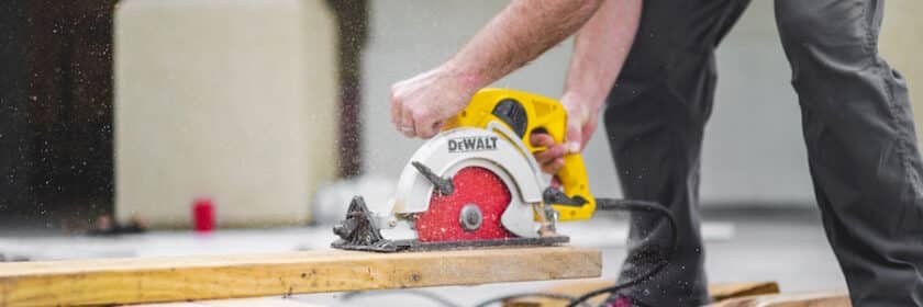 Man cutting wood using electric cutter