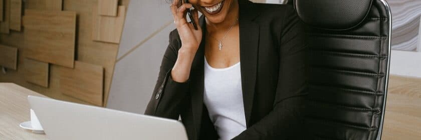 Professional woman working on laptop while talking on the phone