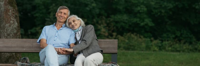 Elderly couple embracing on a park bench